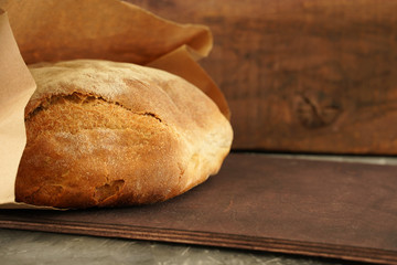freshly baked bread in a paper bag on a wooden table