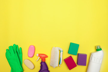 Cleaning. Set of cleaning and detergents in bottles on a yellow background, space for text. Disinfection. Flat lay.