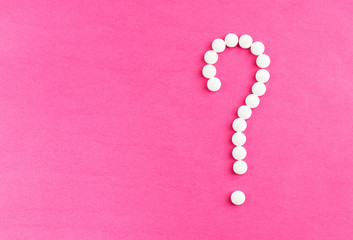 Question mark of white tablets on a pink background. Health care, treatment, pills, pain relief. Copyspace for text. Problem solving concept