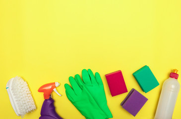 Gloves, cleaning agent and brush on a yellow background, cleaning. Washing dishes. Flat lay. Space...