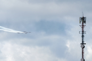 Obraz premium Formation of jets zooming past a communications tower