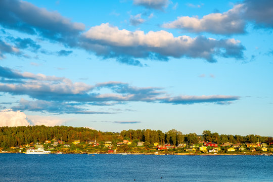 Panoramic sunset view of Lindoya island on Oslofjord harbor with summer cabin houses at wooded shoreline in early autumn near Oslo, Norway