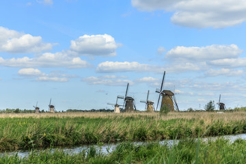 Naklejka premium Old windmill on dutch landscape, Kinderdijk is a village in the municipality of Molenlanden, in the province of South Holland, Netherlands