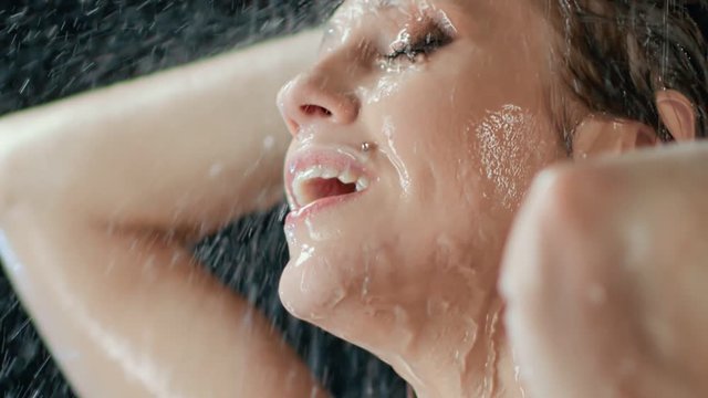 Closeup face of sensual naked woman smiling taking shower. Shot on RED Raven 4k Cinema Camera