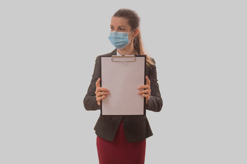 Business woman in face mask holds a writing board in focus