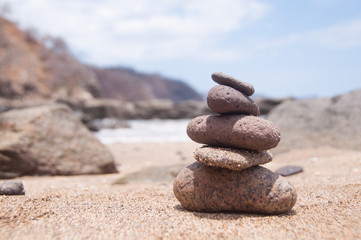Fototapeta na wymiar Five stones balancing at the beach in a bright day