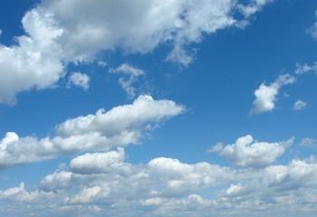 White clouds of different sizes and shapes in the sky above the plain during a beautiful spring day