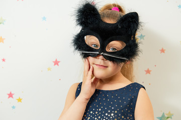 Happy Halloween 2021. Little girl child in black cat mask, carnival costume. Funny face