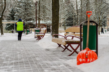 snow storm in the city. Roads and sidewalks covered with snow. Worker shovel clears snow. Bad winter weather. Street cleaning after snowstorm.