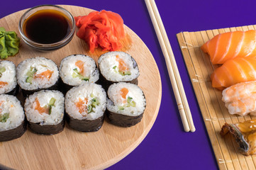 Sushi set sashimi with salmon, shrimp, eel and sushi rolls served on bamboo mat and wooden board