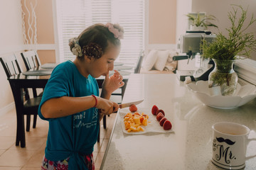 niña joven preparando 3 boles de yogur con frutos del bosque congelados