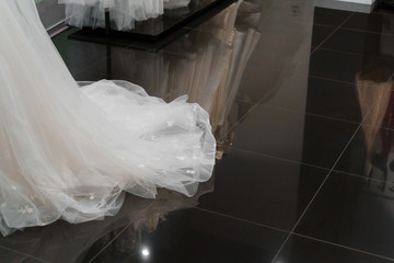 Wedding dress made of silk chiffon, tulle and lace. Beautiful White cream bridal dress on hangers in wedding salon. Photo with empty space right side for text of advertise