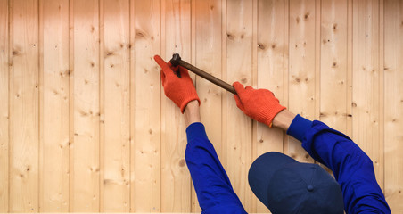Young man contractor worker is holding a hammer