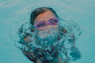 niña joven divirtiéndose en piscina en casa