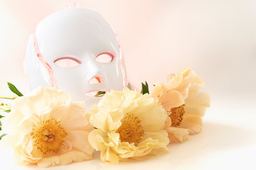 Color therapy mask glowing red on, peonies