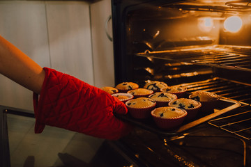 hermanas j&oacute;venes ayudando madre en cocina moderna horneando bizcocho