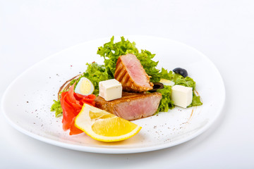 Medallions of tuna with a vegetable garnish. Composition: Tuna, paprika, Brussels sprouts, cauliflower, lemon. 