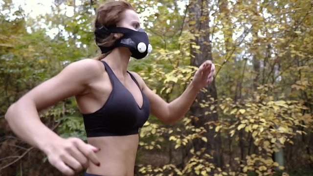 Hypoxic mask. Athletic girl runs in a hypoxic mask.