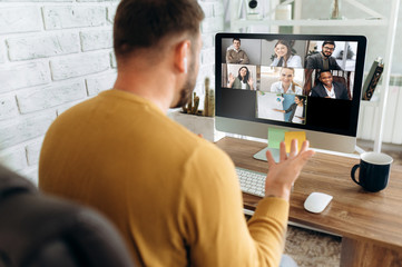 Fototapeta na wymiar Video conference. Business partners communicate via video conference using computer. The guy talks with his business partners appearance about plans and strategy. Distant work