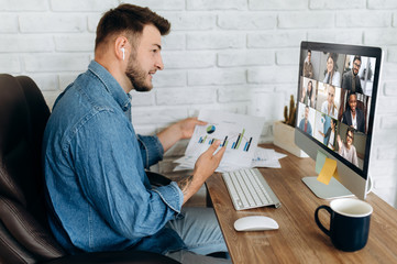 Fototapeta na wymiar Online business meeting. A young business man communicates by video conference with his business team about a work strategy and plan. Work from home