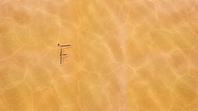 Handwritten animated text in the sand, day of the week-Friday.
