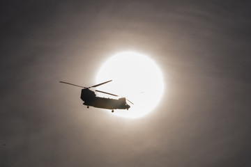 Fototapeta na wymiar Helicopter flying across the sun