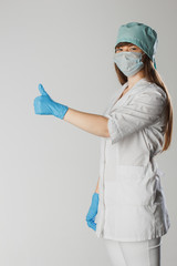 Fototapeta na wymiar Young woman nurse on isolated background showing gesture approvals showing thumb up symbol and shape with hands. Medical concept.