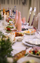 Flowers on the table with food and drinks.