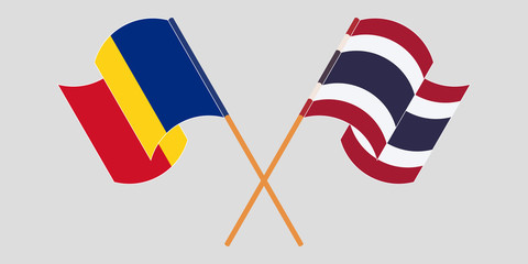 Crossed and waving flags of Romania and Thailand