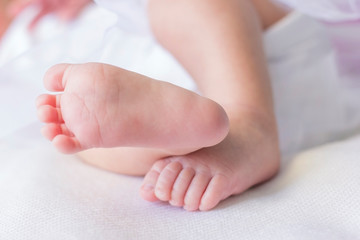 Baby feet on white coverlet. Toes. Horizontal photo. Macro. Close-up. Little feet, focus on one...