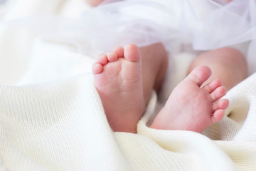 Baby feet on white coverlet. Toes. Feet how a heart or "V". Horizontal photo. Macro. Close-up. The concept of a newborn, care. Maternal capital.