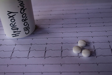 Adverse effects on the heart by hydroxychloroquine or chloroquine. Pills on an electrocardiogram....