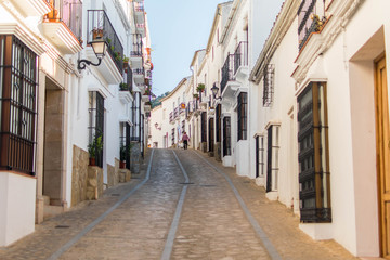 Narrow and cozy street in a white village in Andalusia, Spain.