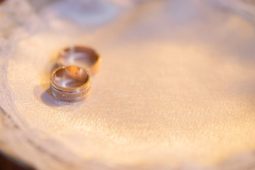 Rings of the bride and groom on a plate.