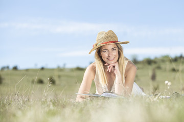 Young beautiful lady enjoying in nature park reading the book