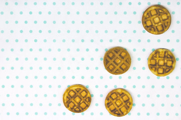 baked round waffles on a white turquoise background copy space