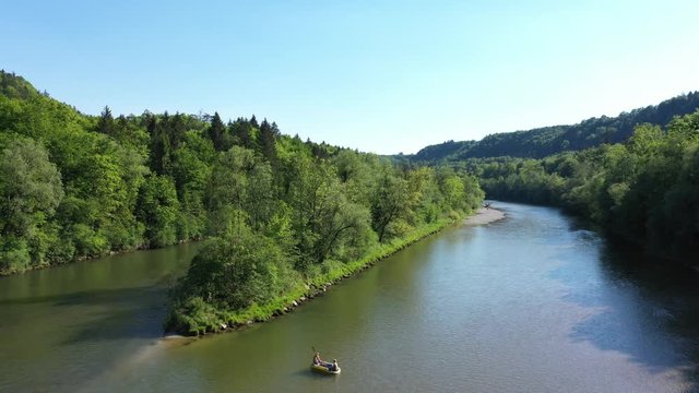 Aerial drone video of Isar river with people on a boat sailing on the river. Bird view of kayaking in Germany near the Alps.