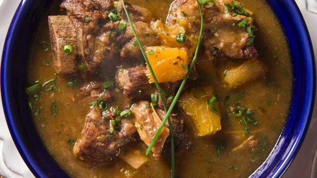 rustic Stew meat with manioc called Vaca atolada in Brazil. Top view with smoke.