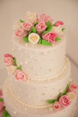 Wedding cake with flowers and green leaves.