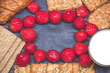 Cookies with milk on a blue background with strawberries copy space
