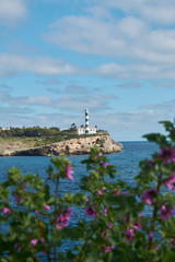 Fototapeta na wymiar Europe, Spain, Balearic Islands, Mallorca. Porto Colom. Walkway along the waterfront. lighthouse.
