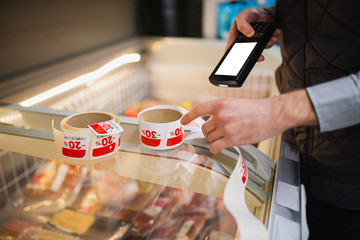 barcode scanner in hand checks the price of products in the supermarket. close-up view © Aleksandr Kolesnikov