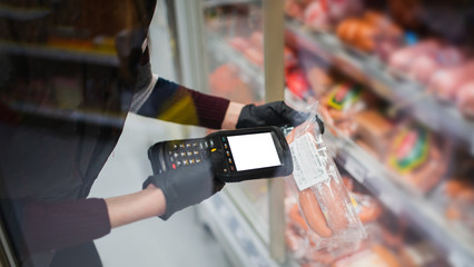 barcode scanner in hand in rubber gloves checks the price of products in the supermarket. close-up...