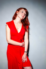 Portrait of Sensual Tranquil Female Girl Posing in Red Dress in Studio Against White Wall