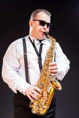 Portrait of Expressive Caucasian Saxophonist in White Shirt Posing in Sunglasses Against Seamless...