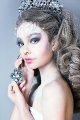 close up portrait of beautiful girl. professional white and blue winter makeup. hair in snow. snow queen