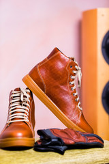Motorcycling Concepts. Closeup of Protective Motorcyclist Leather Tan Sneakers Placed Indoors Along...