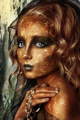 child with professional gold face painting. studio close up portrait of blonde girl with art