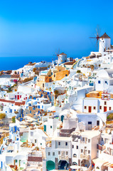 Greece Traveling. View of Greek Traditional Colorful Houses and Windmills of Oia or Ia at Santorini Island in Greece at Noon.