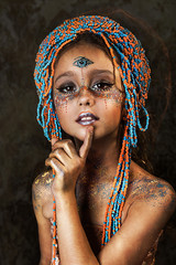 portrait of ethnic dancer colorful girl with big crown of beads. professional creative  makeup. face painting. third eye